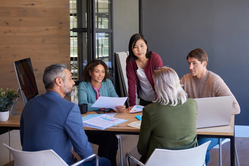 Un groupe de 5 personnes en réunion autour d'une table