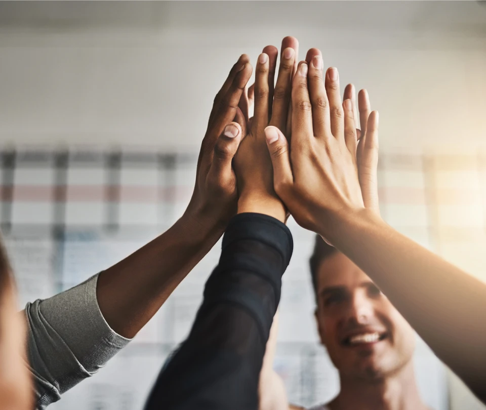 5 mains tendues vers le haut se réunissent