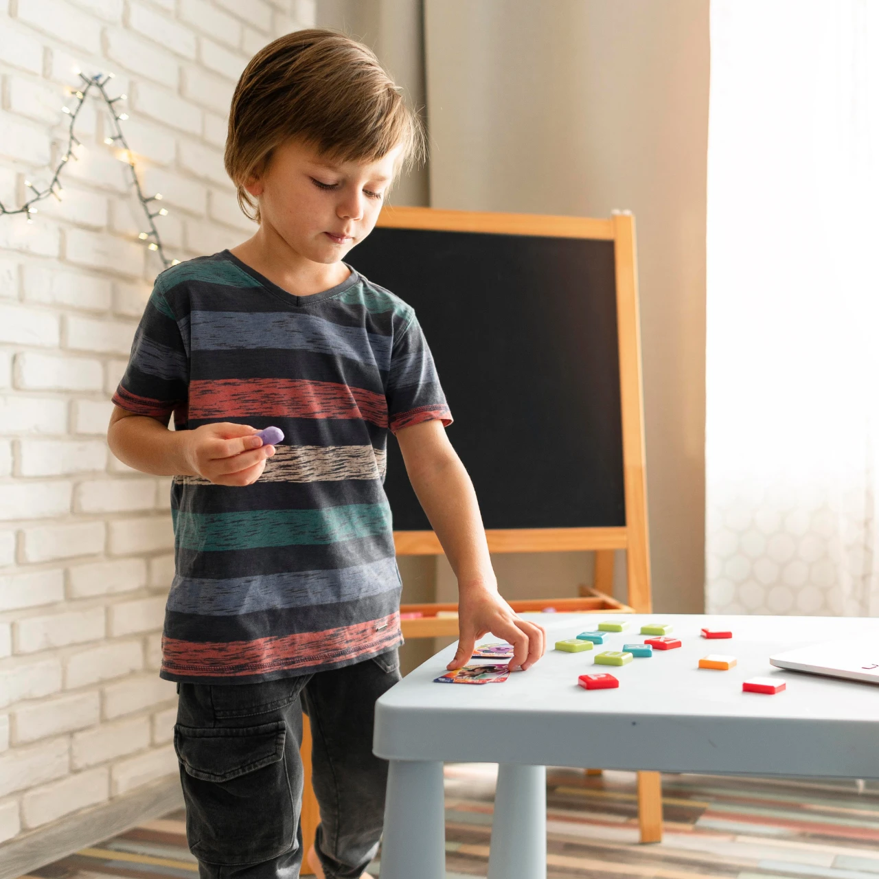 Un enfant debout en train de jouer avec des magnets