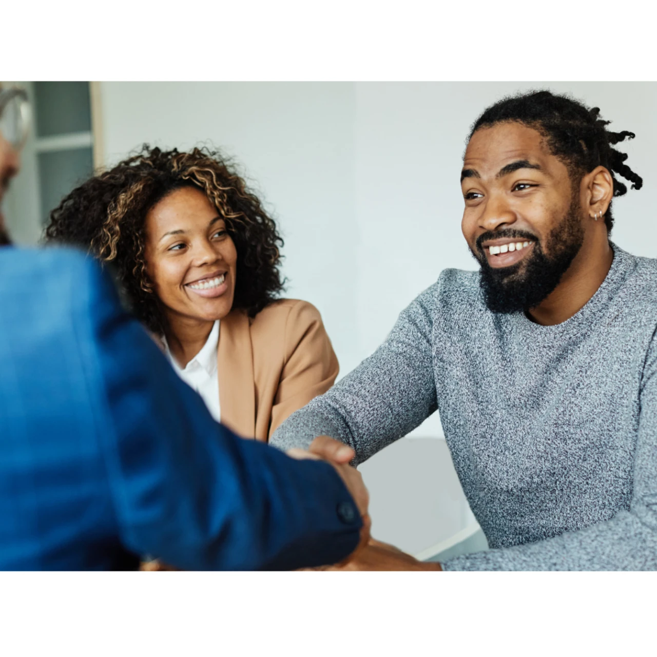 3 personnes discutant, dont 2 se serrant la main 