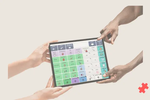 4 mains tenant une tablette allumée sur Grid 3