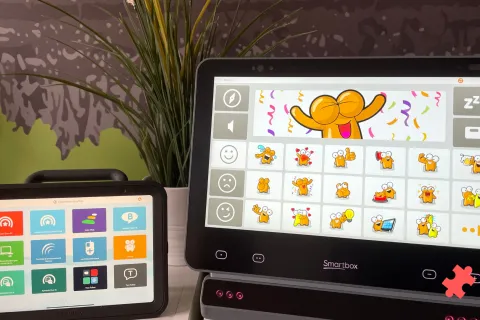 Deux tablettes de communication posée sur une table avec le logiciel Grid 3 allumé
