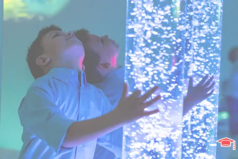 Un enfant mettant ses bras de chaque côté d'une colonne à bulles